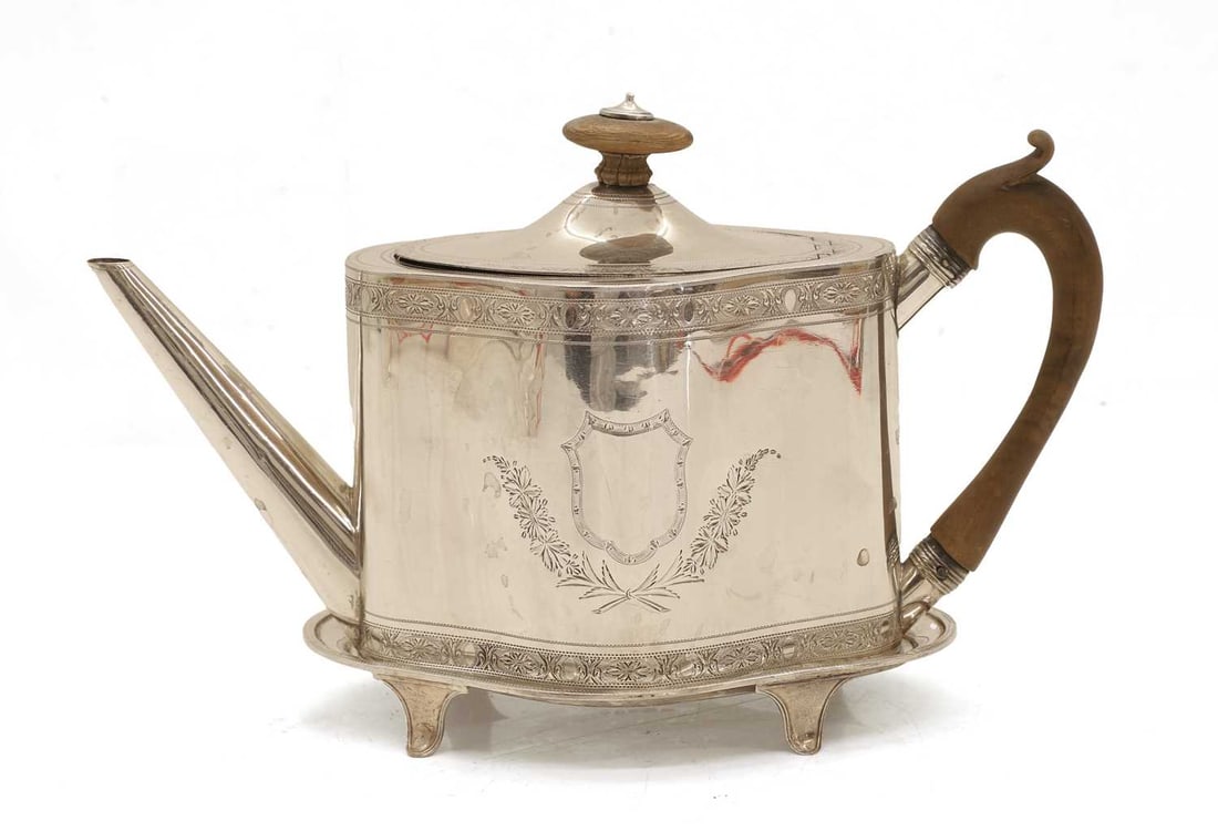 A George III silver teapot on stand,: A George III silver teapot on stand, by Henry Chawner, London, 1792, both pieces with bright-cut engraved decoration and vacant cartouches to the main fields, the teapot with a wooden handle and finia