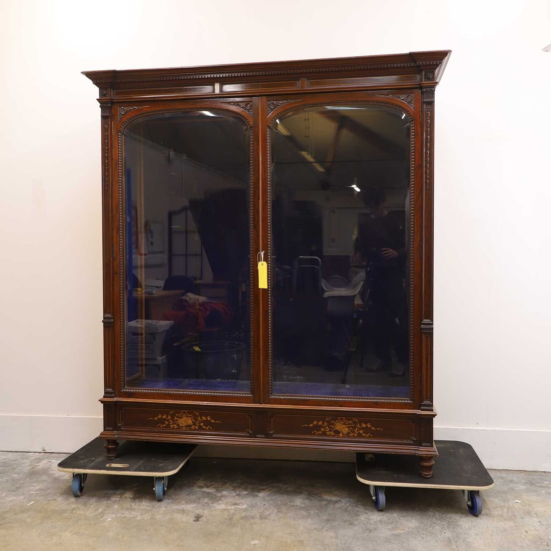 A late Victorian mahogany and boxwood bookcase, late 19th century,: A late Victorian mahogany and boxwood bookcase, late 19th century, the dentil moulded cornice above a tableted frieze, above two glazed doors opening to reveal glass shelves, flanked by architectural