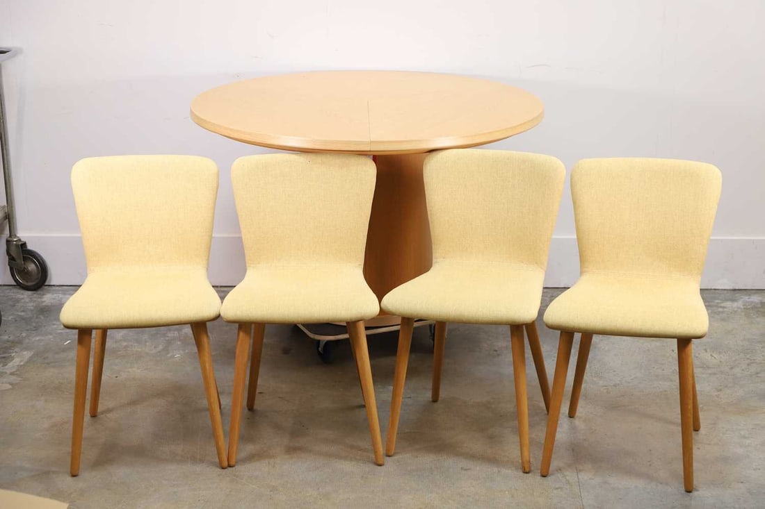 A Contemporary oak circular dining table and chairs,: A Contemporary oak circular dining table and chairs, the circular table with a pale oak top incorporating a concealed extension leaf, raised on a cylindrical pedestal support, together with four