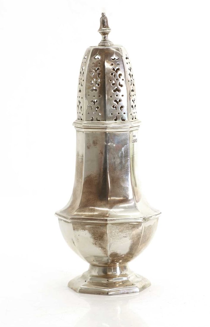 A large silver sugar sifter,: A large silver sugar sifter, by Stokes & Ireland Ltd (William Henry Stokes & Arthur George Ireland), Chester, 1911, the similar formed finial above the pierced decoration to the top over