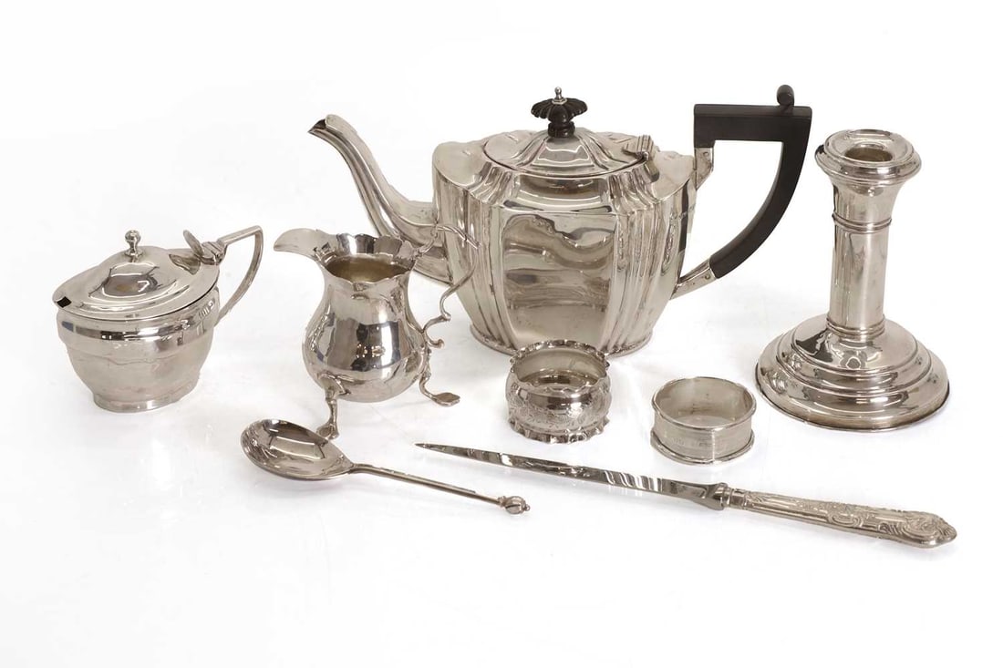 A collection of silver table items,: A collection of silver table items, to include a teapot by John Millward Banks, Chester, 1898, with ebonised handle and finial, and ribbed shape, a silver milk jug, London, marks rubbed, a modern jam 