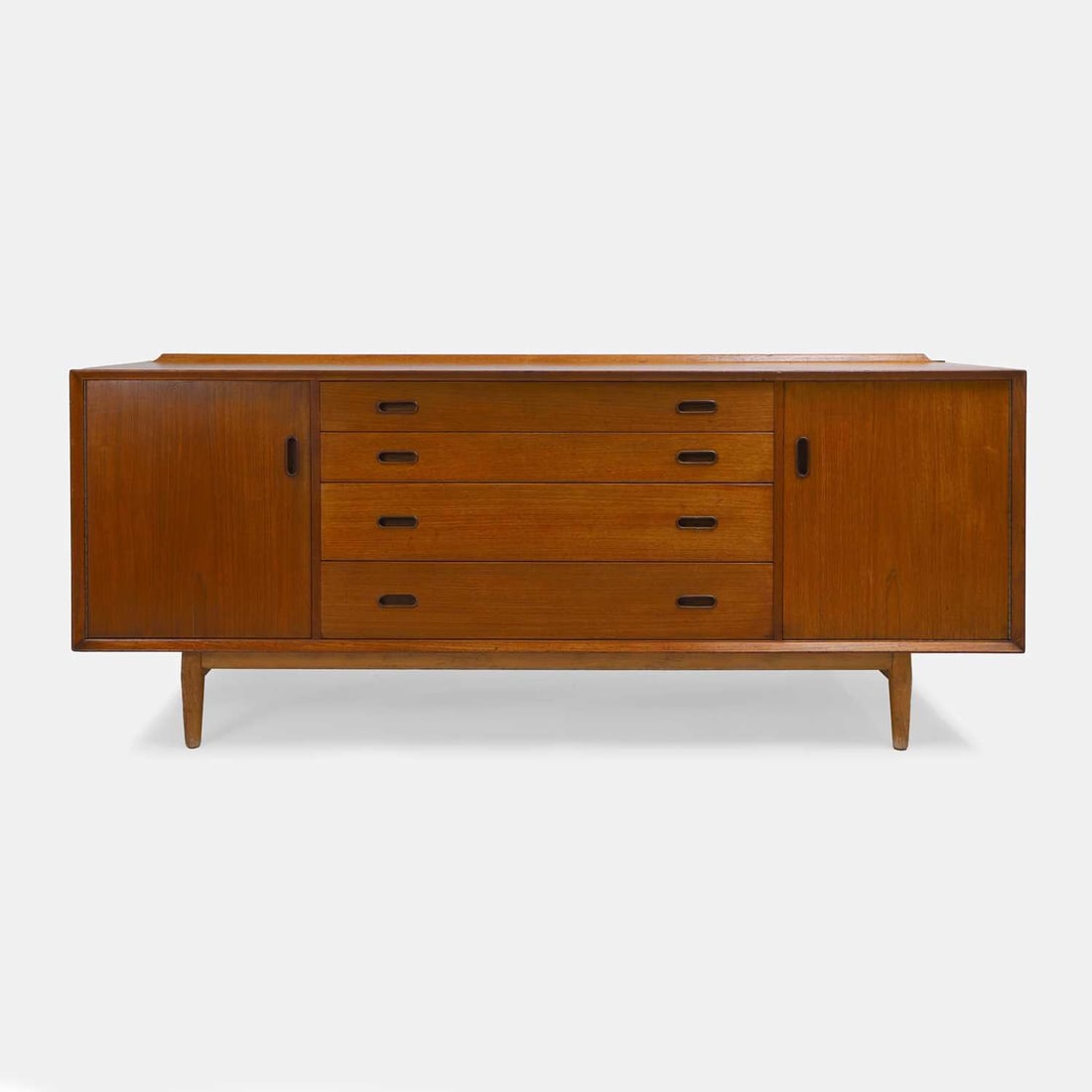Arne Vodder (Danish, 1926-2009), a double-sided sideboard,: Arne Vodder (Danish, 1926-2009), a double-sided sideboard, 1960s, teak, the middle section with a bank of four drawers, two of which contain compartmentalised sections, flanked by two outer cupboards,