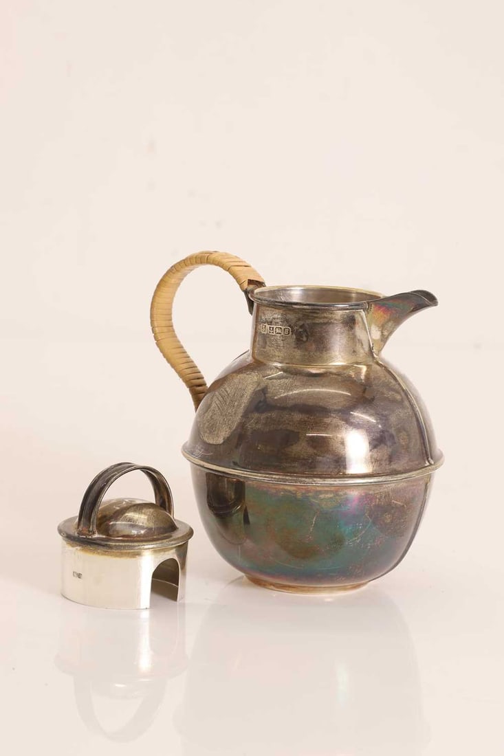 A silver Jersey jug,: A silver Jersey jug, marked MS, Birmingham 1976, of typical baluster form with a broad, rounded body tapering to a short neck, the domed cover with an arched handle, the side-mounted spout wrapped in