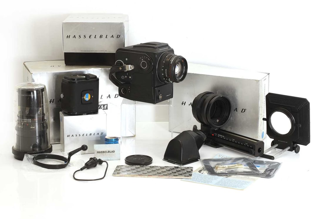 A Hasselblad 500 ELM outfit, circa 1979: A Hasselblad 500 ELM outfit, circa 1979 finished in black, this Hasselblad outfit includes a boxed main body (No. UUE 36002), a waist‑level finder, an eye‑level finder, and two A12 film