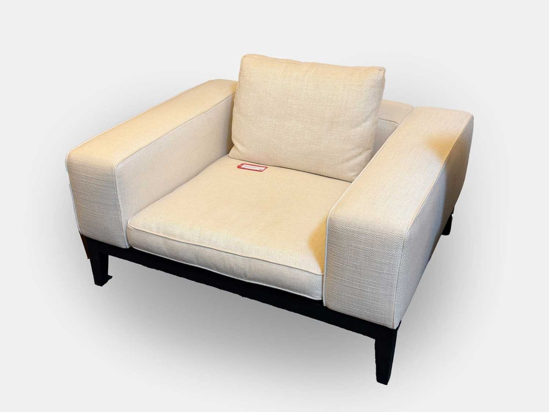 A Camerich 'Moodie' armchair, of recent manufacture,: A Camerich 'Moodie' armchair, of recent manufacture, upholstered in a white woven cloth, with squab cushion base and back, over black square tapering legs 125cm wide, 100cm deep, 60cm high Condition