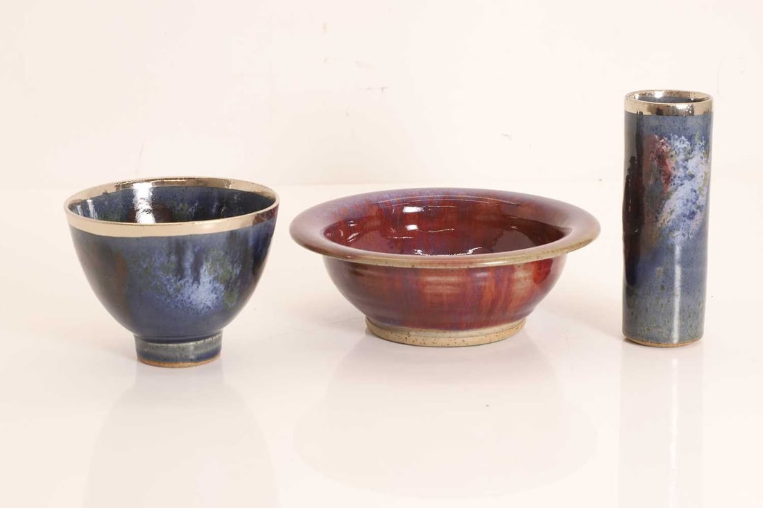 David Fry (b.1948) a stoneware dish,: David Fry (b.1948) a stoneware dish, with a sang de boeuf glaze, impressed 'D Fry', and two glazed stoneware items, a bowl and a sleeve vase, each with a silvered rim, impressed artist's monogram
