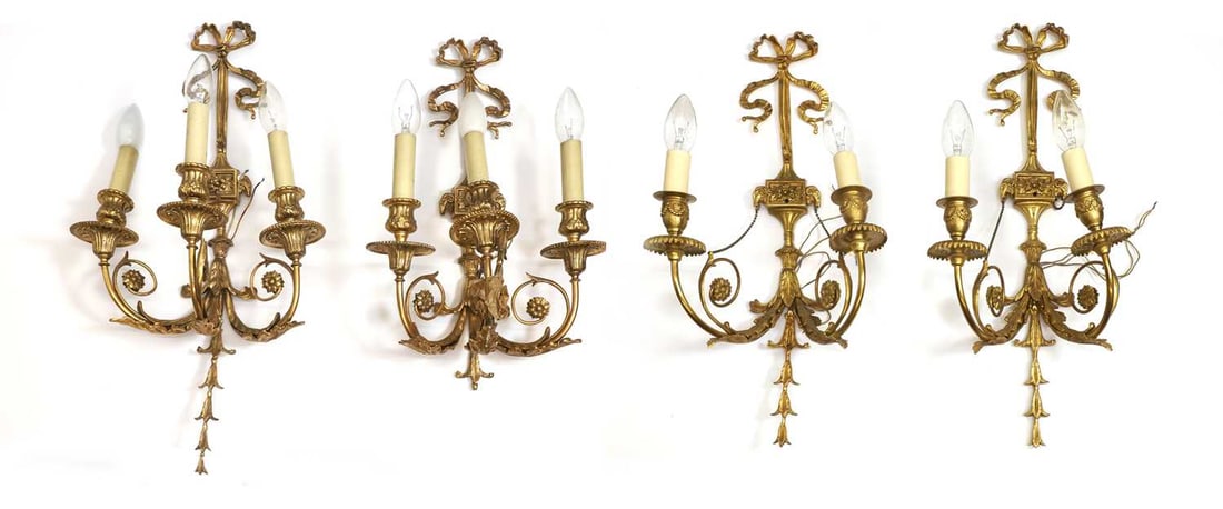 A set of four gilt metal wall appliques, 20th century, French,: A set of four gilt metal wall appliques, 20th century, French, in the Louis style, two pairs, together with a quantity of small cream shade The largestm 61.5cm long 4 Condition Report: One with loss a