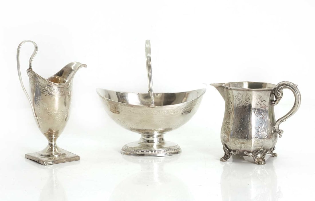 A George III silver sugar basket,: A George III silver sugar basket, maker's mark rubbed, London, 1774, with swing handle, and floral engraved decoration with an initialled cartouche, together with a helmet cream jug, London, marks