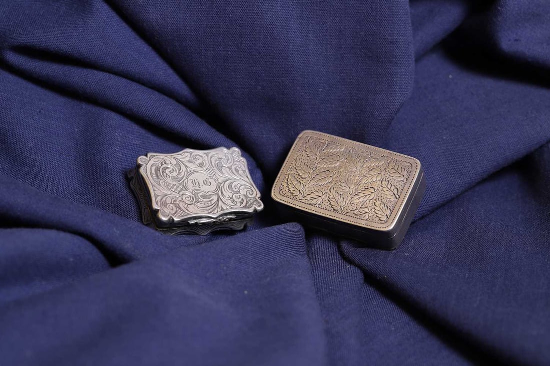 Two silver vinaigrettes,: Two silver vinaigrettes, the first by Nathaniel Mills, Birmingham 1846, with chased decoration and a pierced grille, the second by William Pugh, Birmingham 1815, with two hinged compartments, one