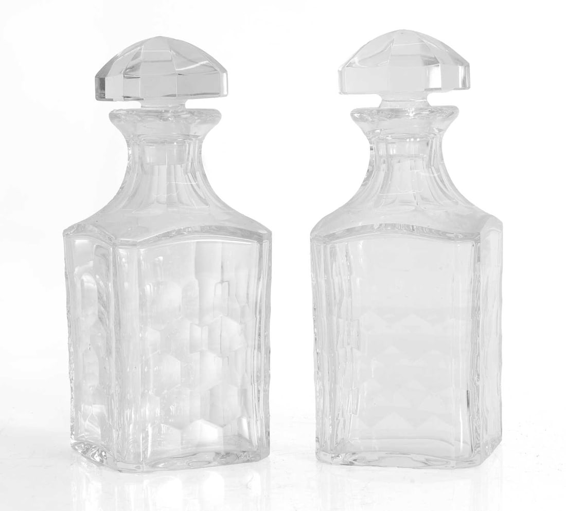 A pair of Baccarat cut and moulded glass decanters,: A pair of Baccarat cut and moulded glass decanters, of faceted tapering rectangular form, each with a faceted mushroom stopper, labelled 9.5cm wide, 24.5cm high, 2