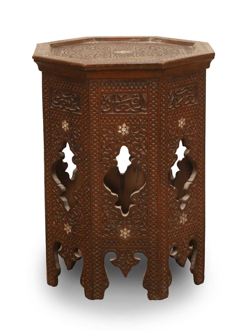 An octagonal carved hardwood occasional table, late 19th/early 20th century, Syrian,: An octagonal carved hardwood occasional table, late 19th/early 20th century, Syrian, in the style retailed by Liberty & Co, London, the octagonal top deeply carved with geometric motifs, centred b