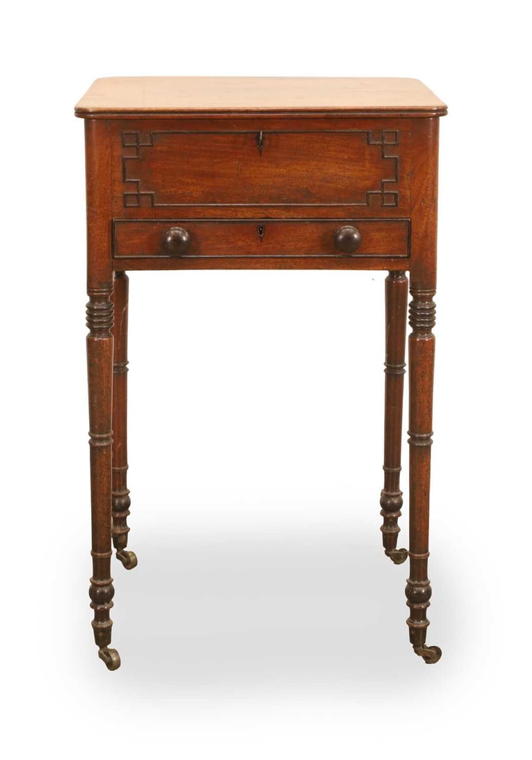 A small mahogany side table, 19th century,: A small mahogany side table, 19th century, with single drawer, the top locking section, opening to reveal a compartment, decorated with geometric moulding, on turned legs and with brass castors