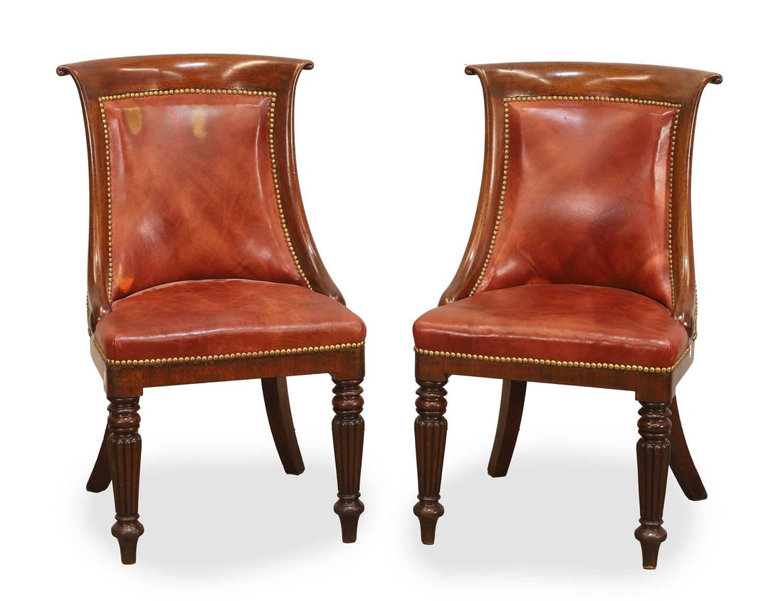 A pair of Victorian rosewood side chairs, early 20th century,: A pair of Victorian rosewood side chairs, early 20th century, with studded red leather upholstered seats and backs, the frame with scrolled back and terminating on reeded front legs and outswept back 