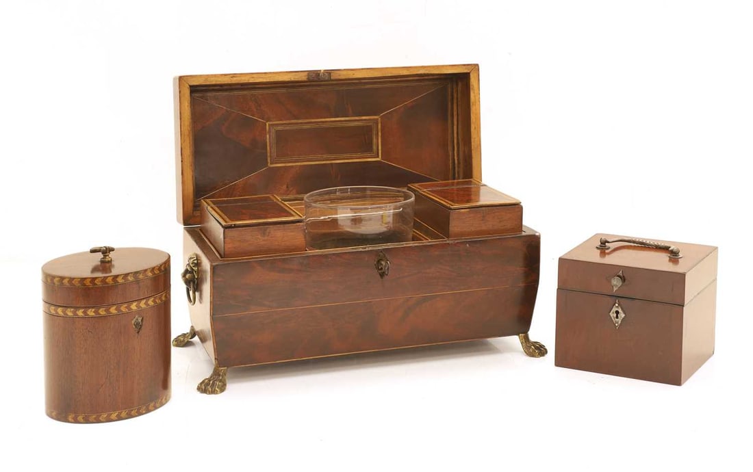 A Regency mahogany and boxwood line-inlaid tea caddy, 19th century and later,: A Regency mahogany and boxwood line-inlaid tea caddy, 19th century and later, the hinged lid opening to reveal twin hinged compartments with central glass mixing bowl, either side with lions masks