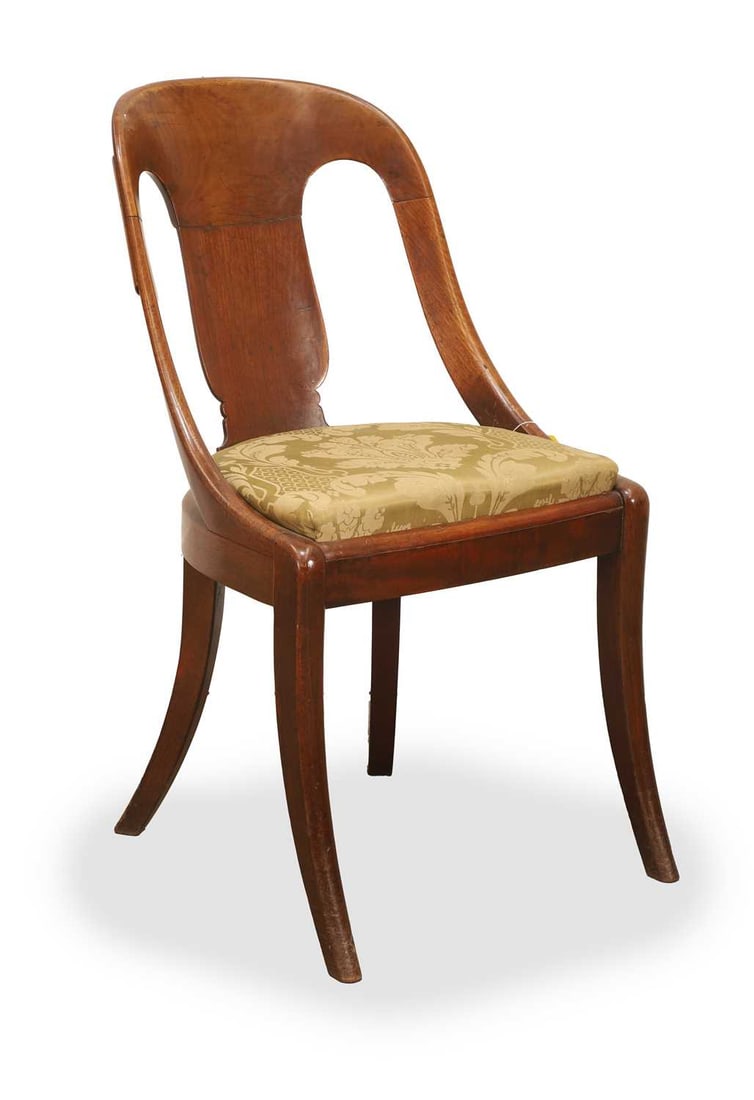 a Regency mahogany 'gondola' hall chair early 19th century,: a Regency mahogany 'gondola' hall chair early 19th century, the curved tablet back, above a shaped splat, with upholstered drop-in seat covered in a pale green floral damask, raised on sabre front leg