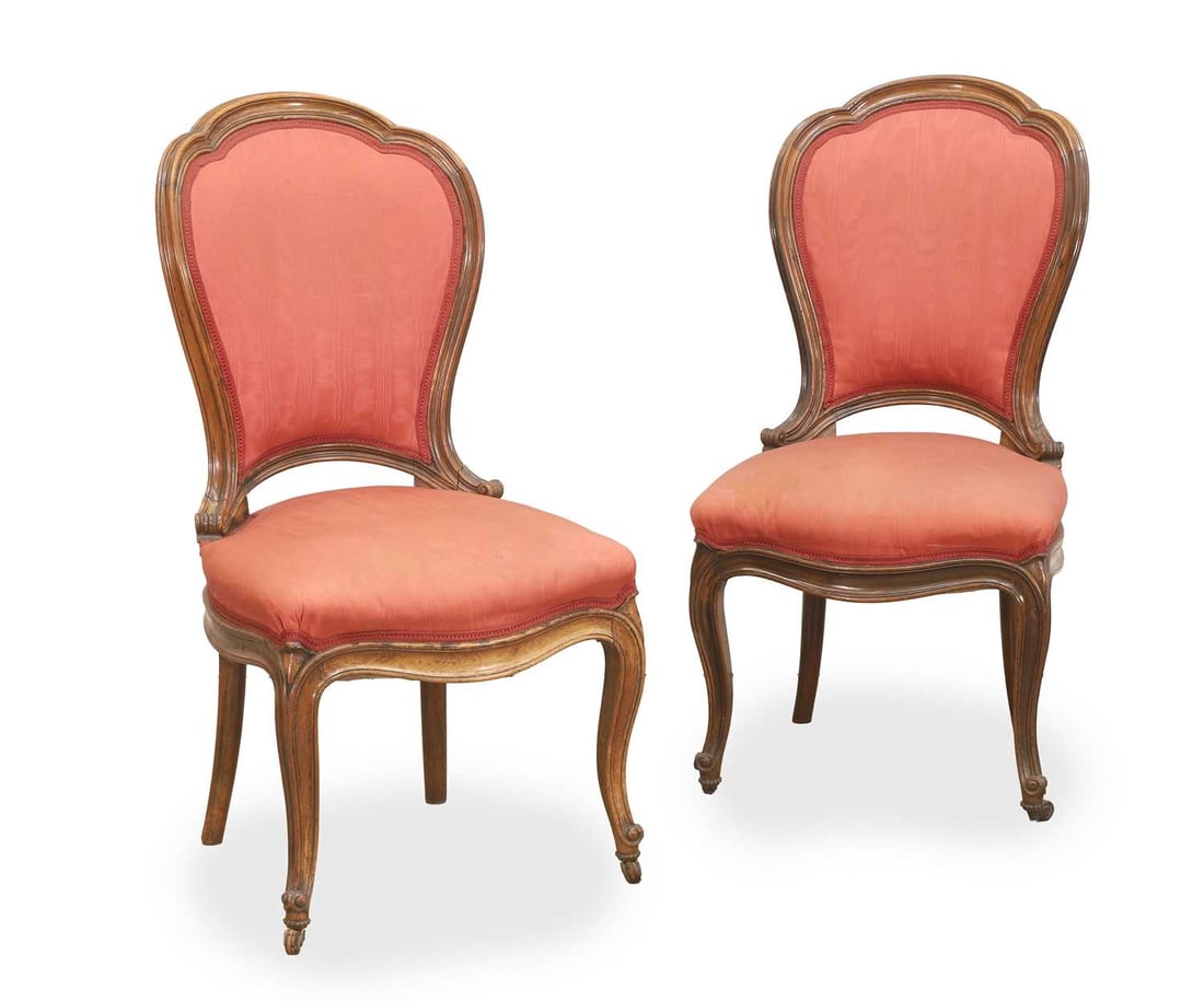 A pair of rosewood show wood upholstered salon chairs, 19th century,: A pair of rosewood show wood upholstered salon chairs, 19th century, with shaped frames, terminating with soft cabriole legs and the front supports with castors, with a pink upholstered seat and back