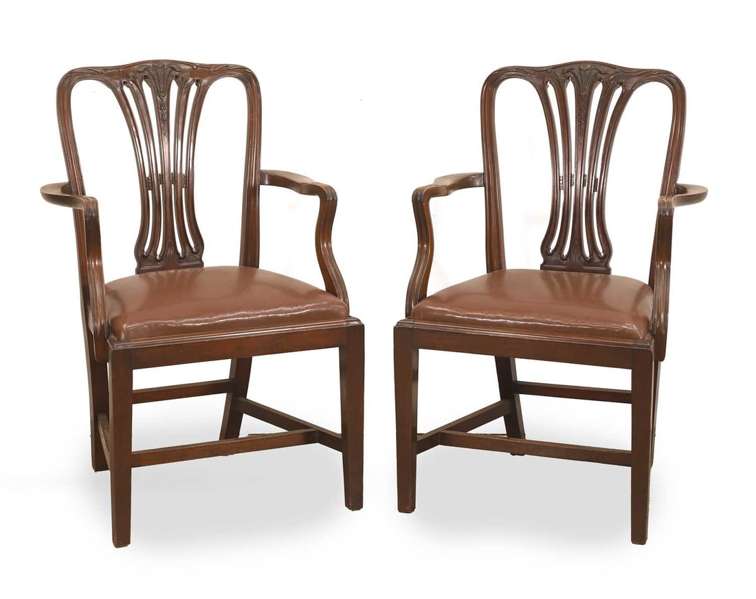 A pair of mahogany elbow chairs, 19th century,: A pair of mahogany elbow chairs, 19th century, with carved Prince of Wales feather cresting and brown leather drop in seats 60.5cm wide, 54cm deep, 64cm high 2