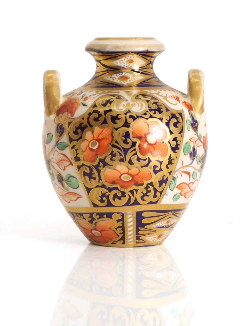 A Crown Derby urn,: A Crown Derby urn, decorated with the Witches Imari pattern, with a red signed mark to the base 7cm wide, 8.5cm high Condition Report: Some fading to the gilding. Pitting to the glaze. Fritting and