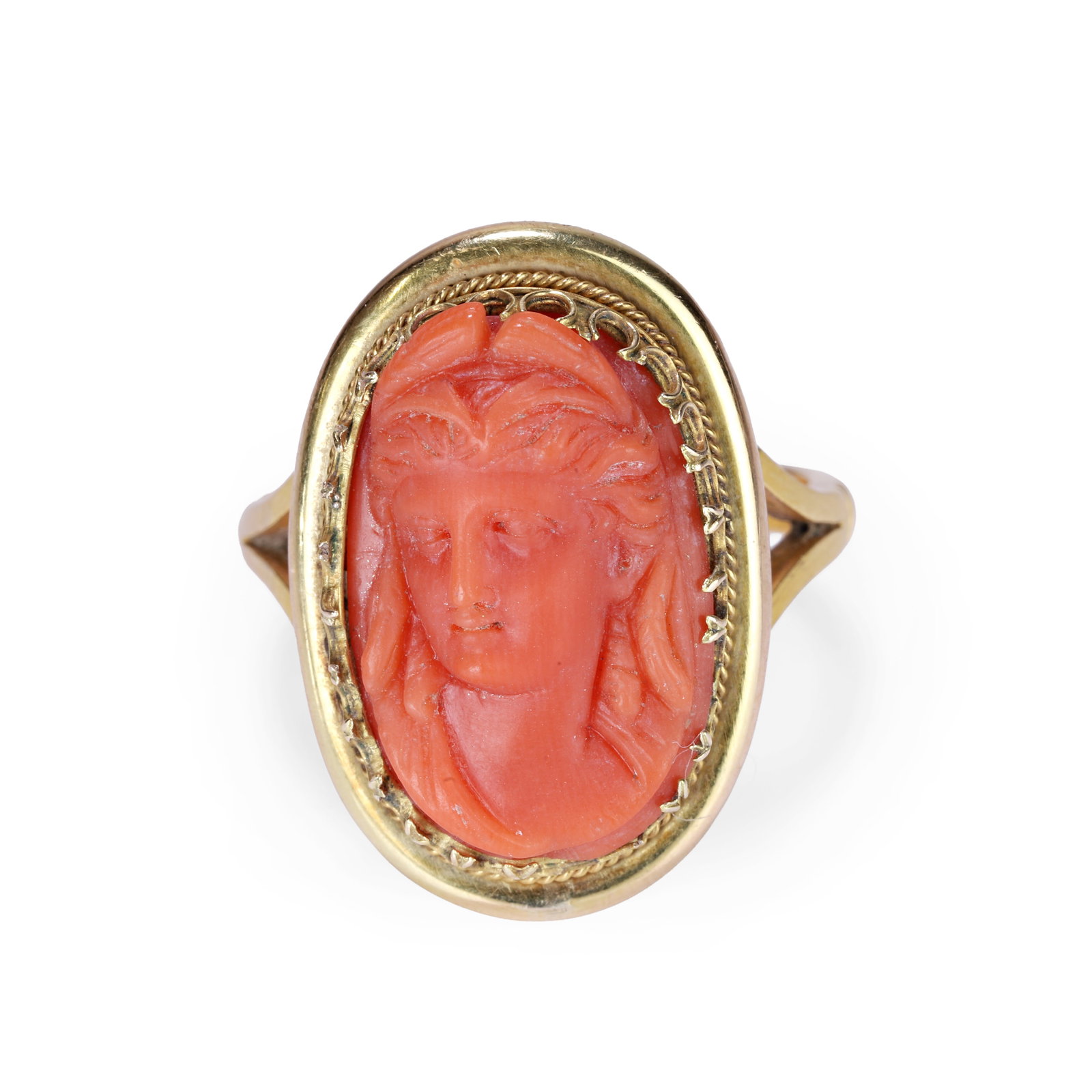 A coral cameo ring,: A coral cameo ring, the oval carved coral depicting a classical female head, claw set with scalloped cut downs with rope edging to a plain border, the straight band with split shoulder and banding det