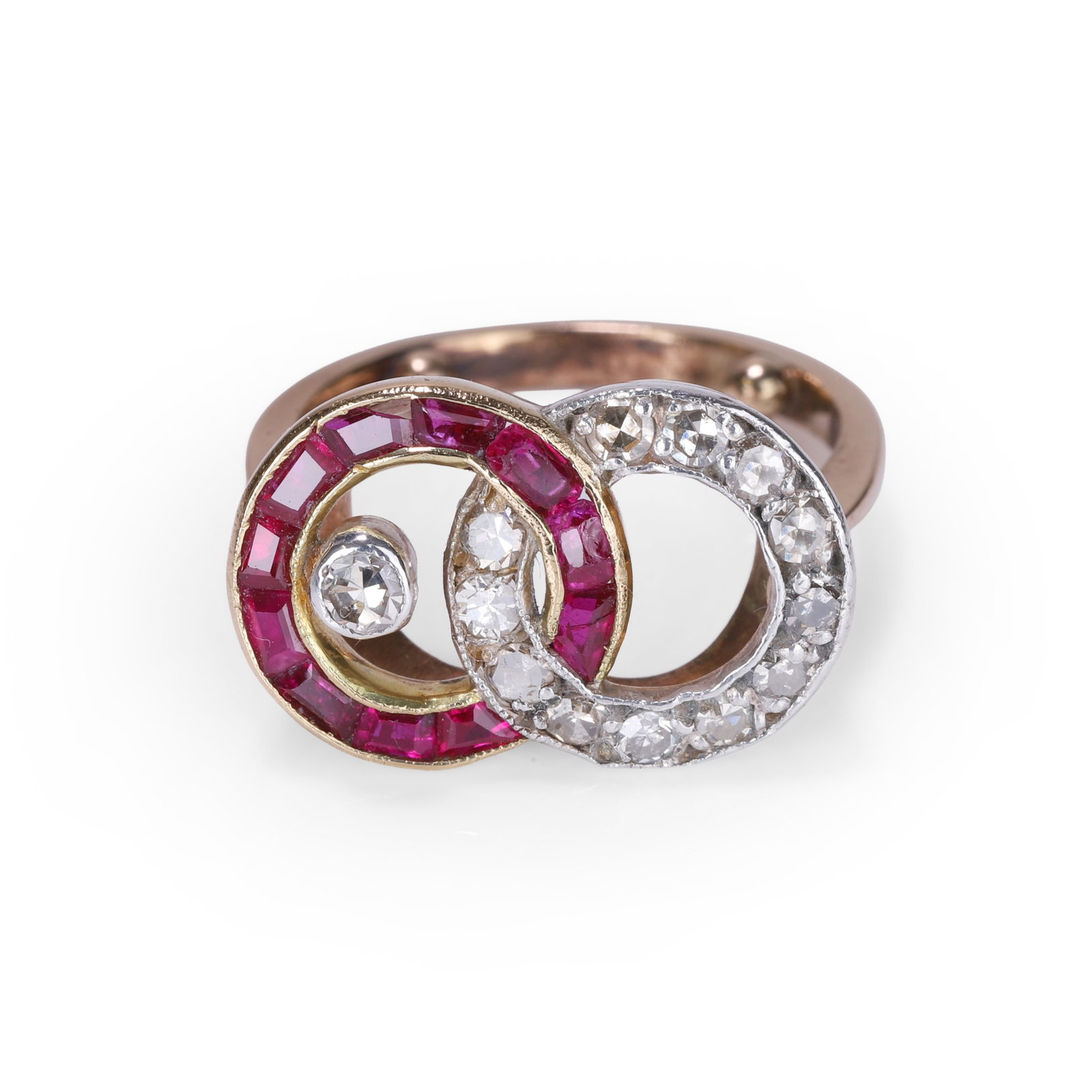 A ruby and diamond interlocking circle ring,: A ruby and diamond interlocking circle ring, designed as two interlocking loops, one grain set with eight cut diamonds, the other channel set with calibre cut rubies and with a central eight cut