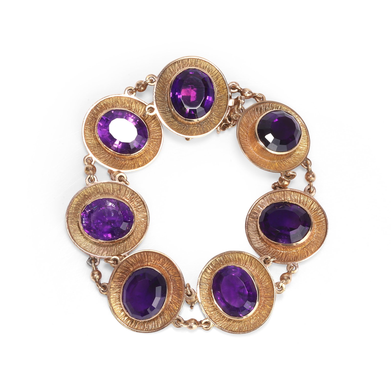 A 9ct gold amethyst panel bracelet,: A 9ct gold amethyst panel bracelet, comprising seven oval faceted amethysts, rub over set to a textured concave border with a double row of chain joining each with an integrated clasp and safety chain