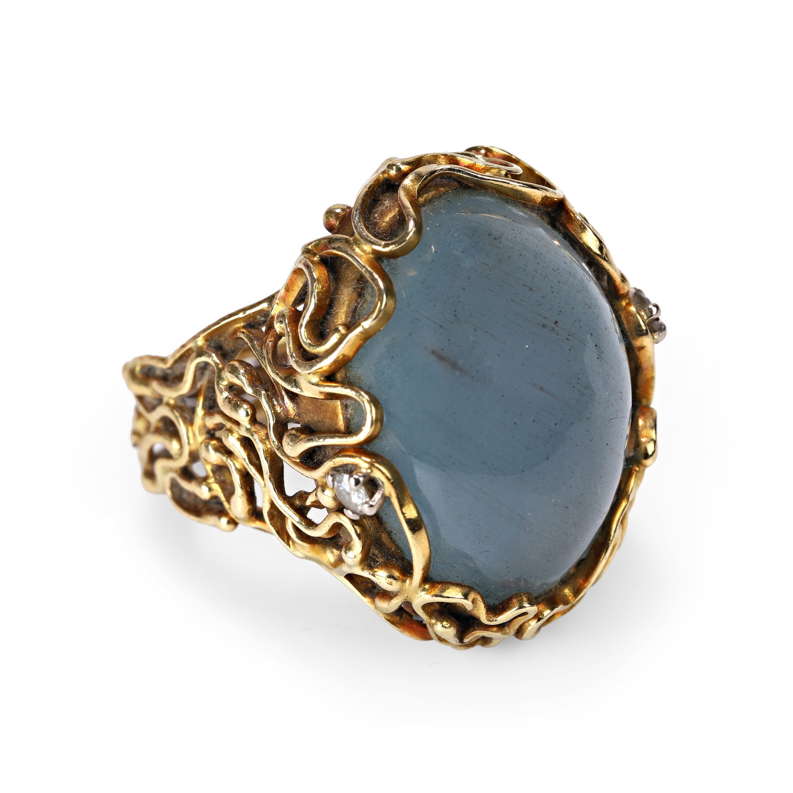 An 18ct gold aquamarine and diamond ring, circa 1969,: An 18ct gold aquamarine and diamond ring, circa 1969, of abstract design, centrally set with an oval cabochon aquamarine to a wirework mount with two round brilliant diamond accents, sponsor mark for