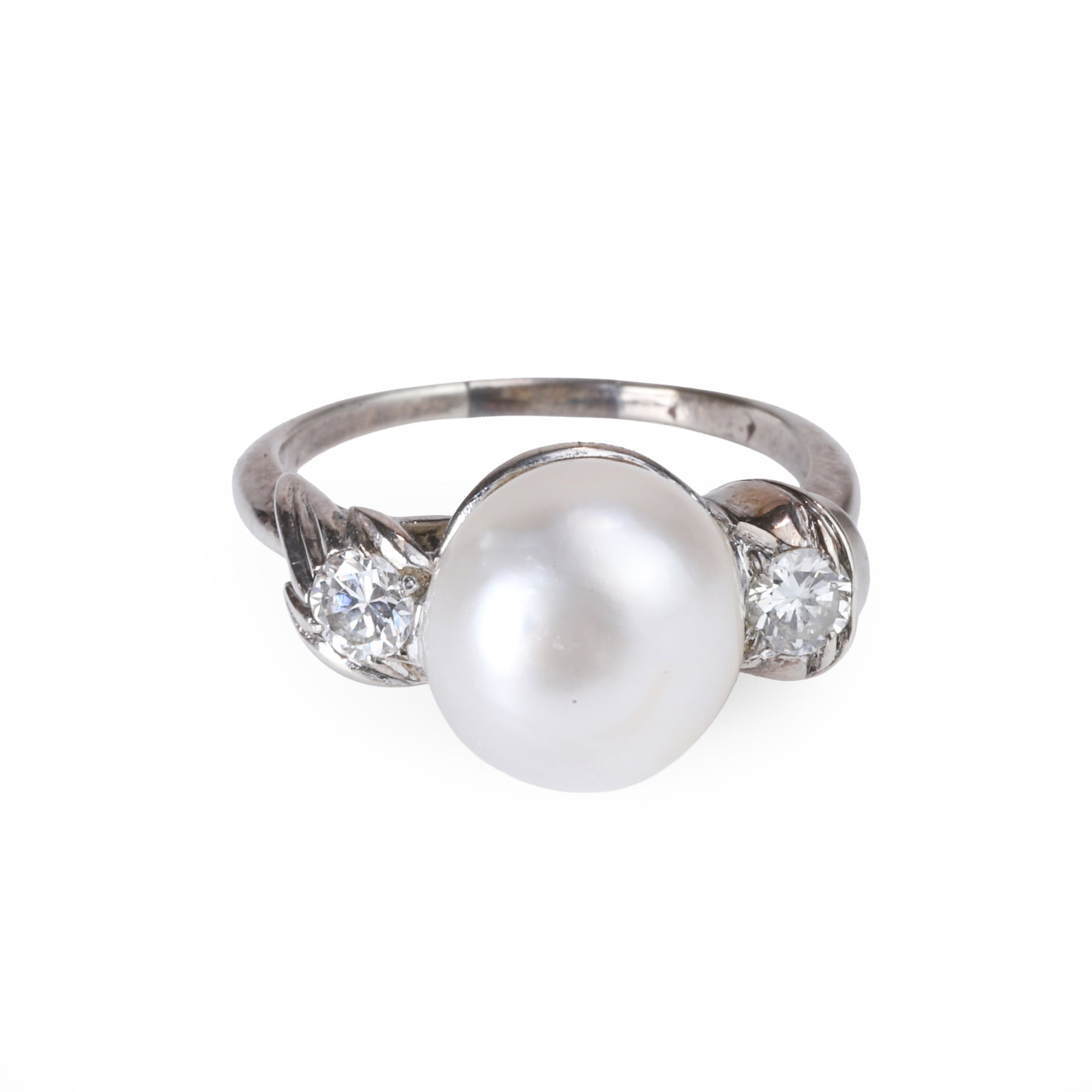 A natural saltwater pearl and diamond ring,: A natural saltwater pearl and diamond ring, comprising a button-shaped natural saltwater pearl flanked by two round brilliant cut diamonds, mounted in unmarked white metal (Ring size L; 3.7g) Footnote