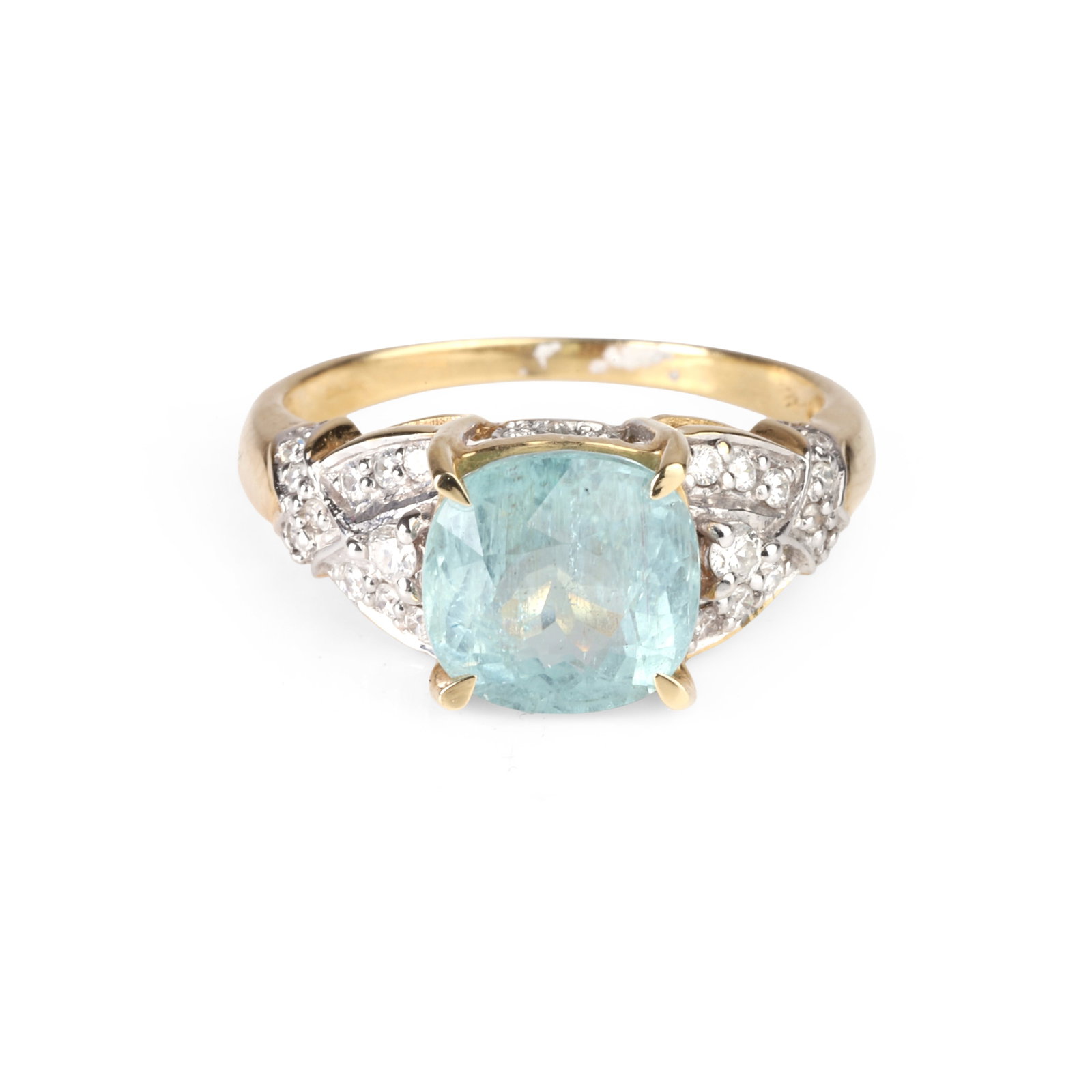 An 18ct gold tourmaline and diamond ring,: An 18ct gold tourmaline and diamond ring, the pale blue cushion shaped tourmaline claw set and flanked by a round brilliant cut diamond to each side, with a thread and grain set diamond cross over sho