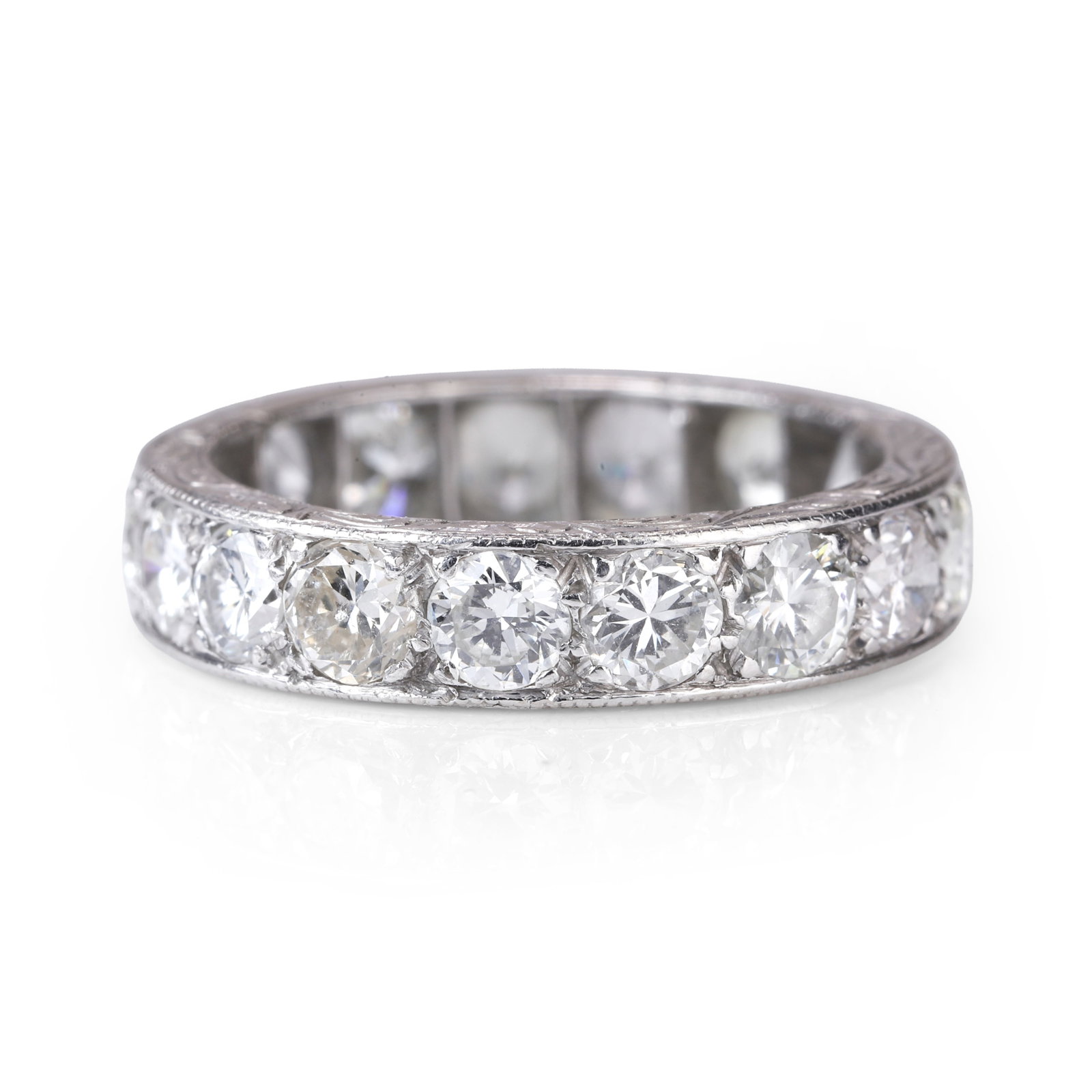 A diamond full eternity ring,: A diamond full eternity ring, thread and grain set with seventeen round brilliant cut diamonds, total approximate diamond weight 2.50ct, hand engraved to the edges with scroll design and PLATINUM with