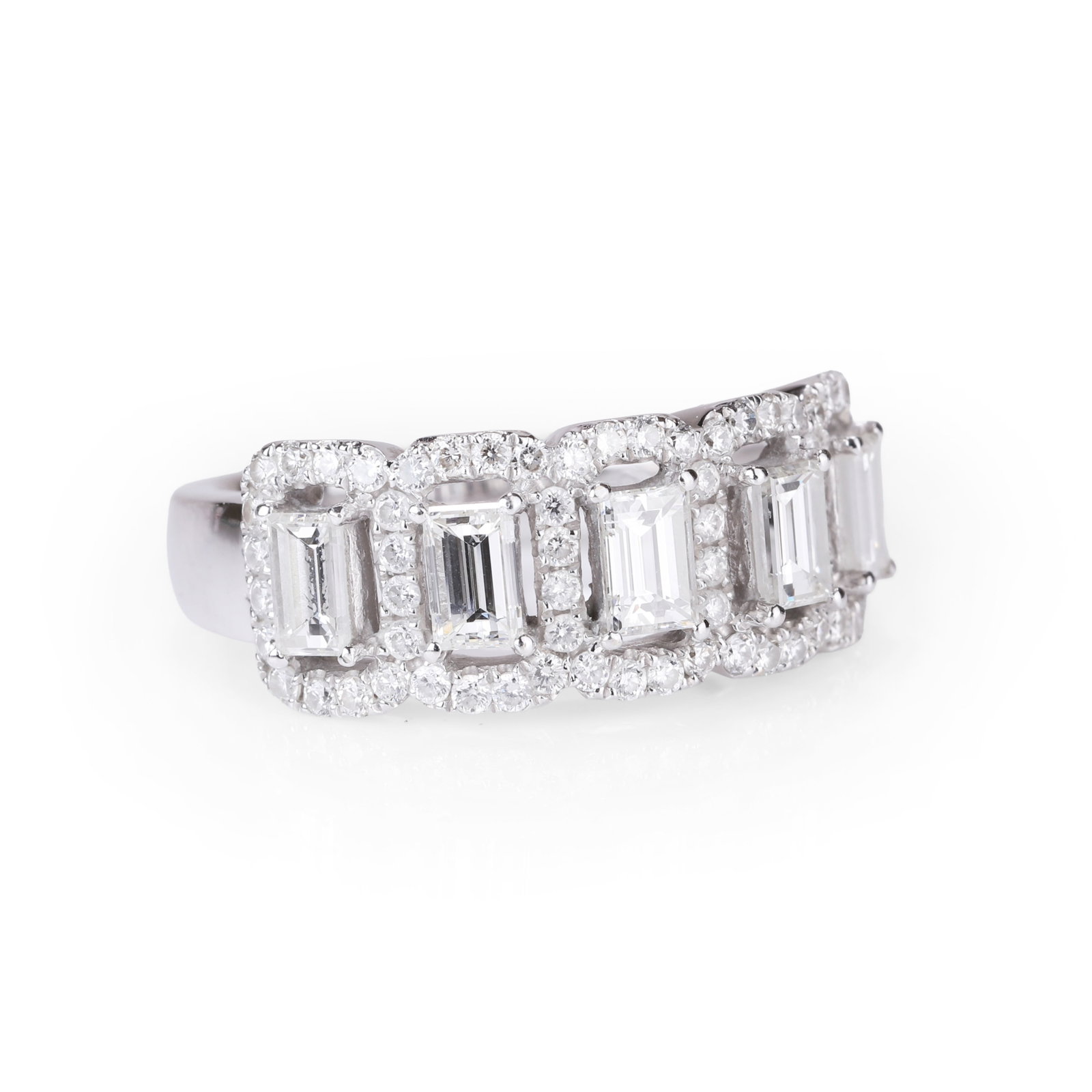 An 18ct white gold half eternity diamond ring,: An 18ct white gold half eternity diamond ring, comprising five baguette cut diamonds, claw set and each surrounded by an open halo of round brilliant cut diamonds to a slightly tapering straight band.