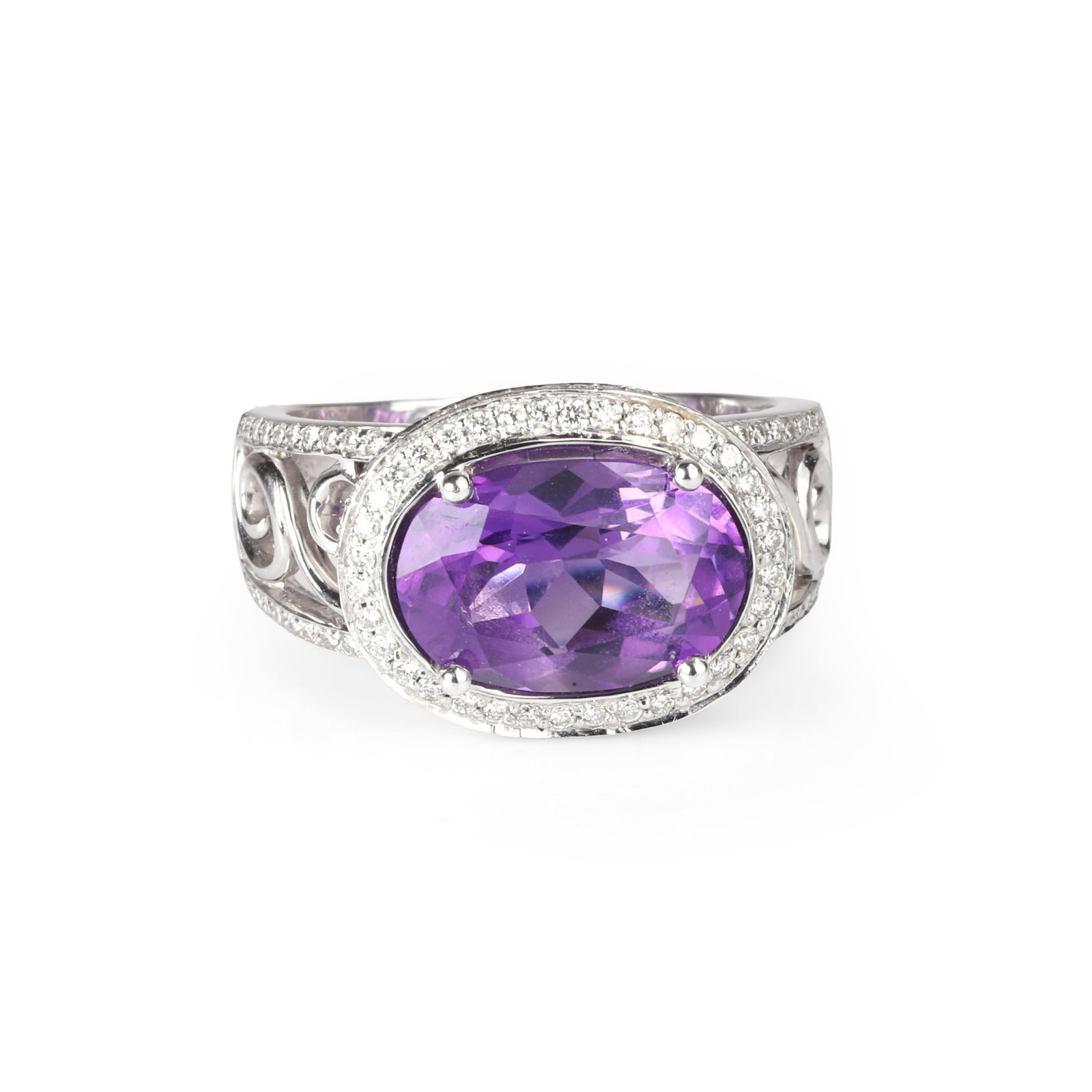 An amethyst and diamond ring,: An amethyst and diamond ring, the oval amethyst claw set horizontally with a thread and grain diamond set halo surround to an open shoulder with scroll detail and diamond accents, stamped 750 and test