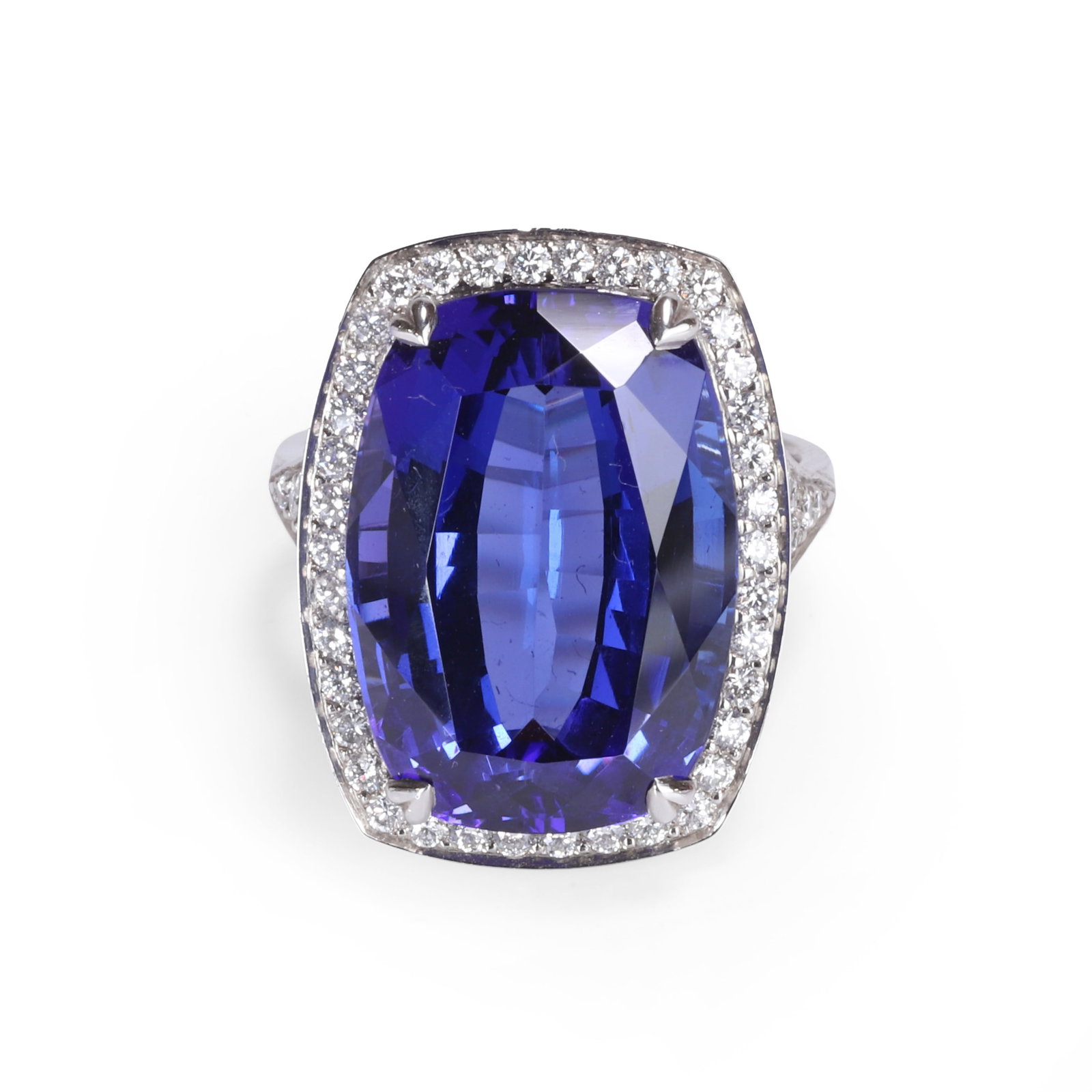 A platinum tanzanite and diamond ring,: A platinum tanzanite and diamond ring, the rectangular cushion shape tanzanite, estimated to weigh approximately 18.00ct, claw set to a diamond halo surround, with diamond set split shoulders leading 