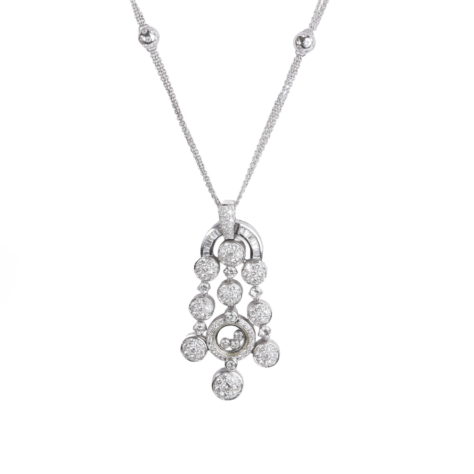 A diamond pendant necklace,: A diamond pendant necklace, designed as an arc of channel set baguette diamonds suspending three articulated drops of pavé set discs interspaced with claw set round brilliant cut diamonds; the ce
