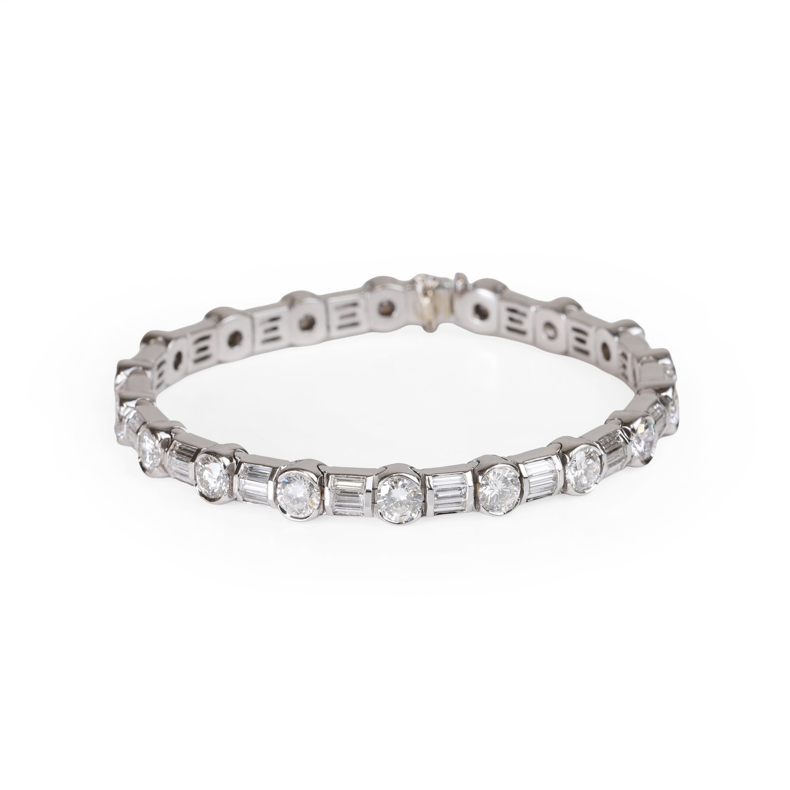 A diamond line bracelet,: A diamond line bracelet, alternately set with round brilliant cut diamonds and trios of baguette cut diamonds, mounted in white metal stamped 750 and surface tested as 18ct gold, total diamond weight 