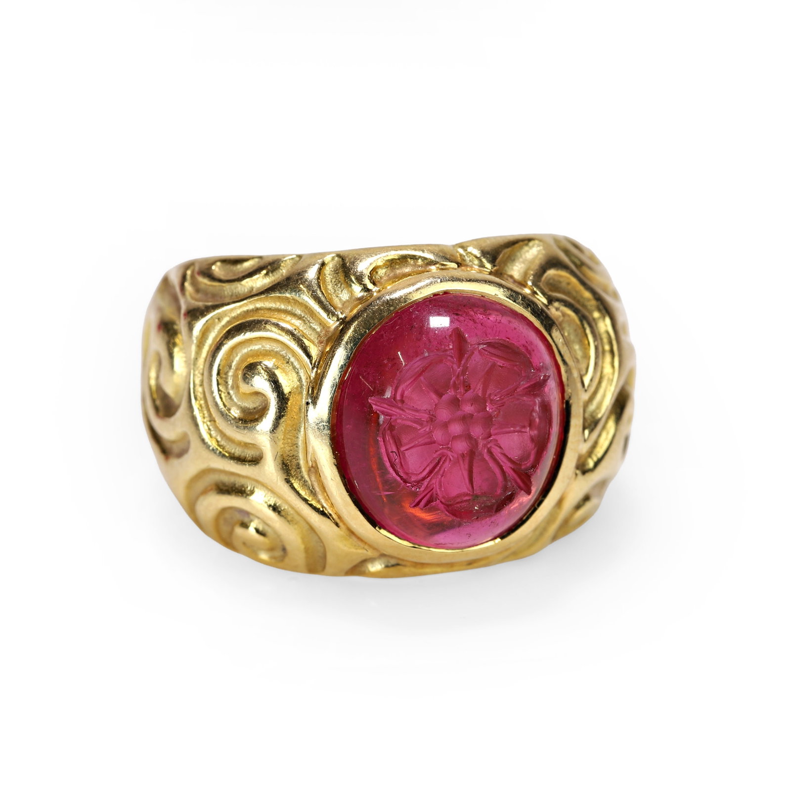 Elizabeth Gage, an 18ct gold pink tourmaline signet ring,: Elizabeth Gage, an 18ct gold pink tourmaline signet ring, the pink tourmaline intaglio, carved with a Tudor rose, collet set within a wide mount decorated with scroll patterns. Signed Gage, maker's ma