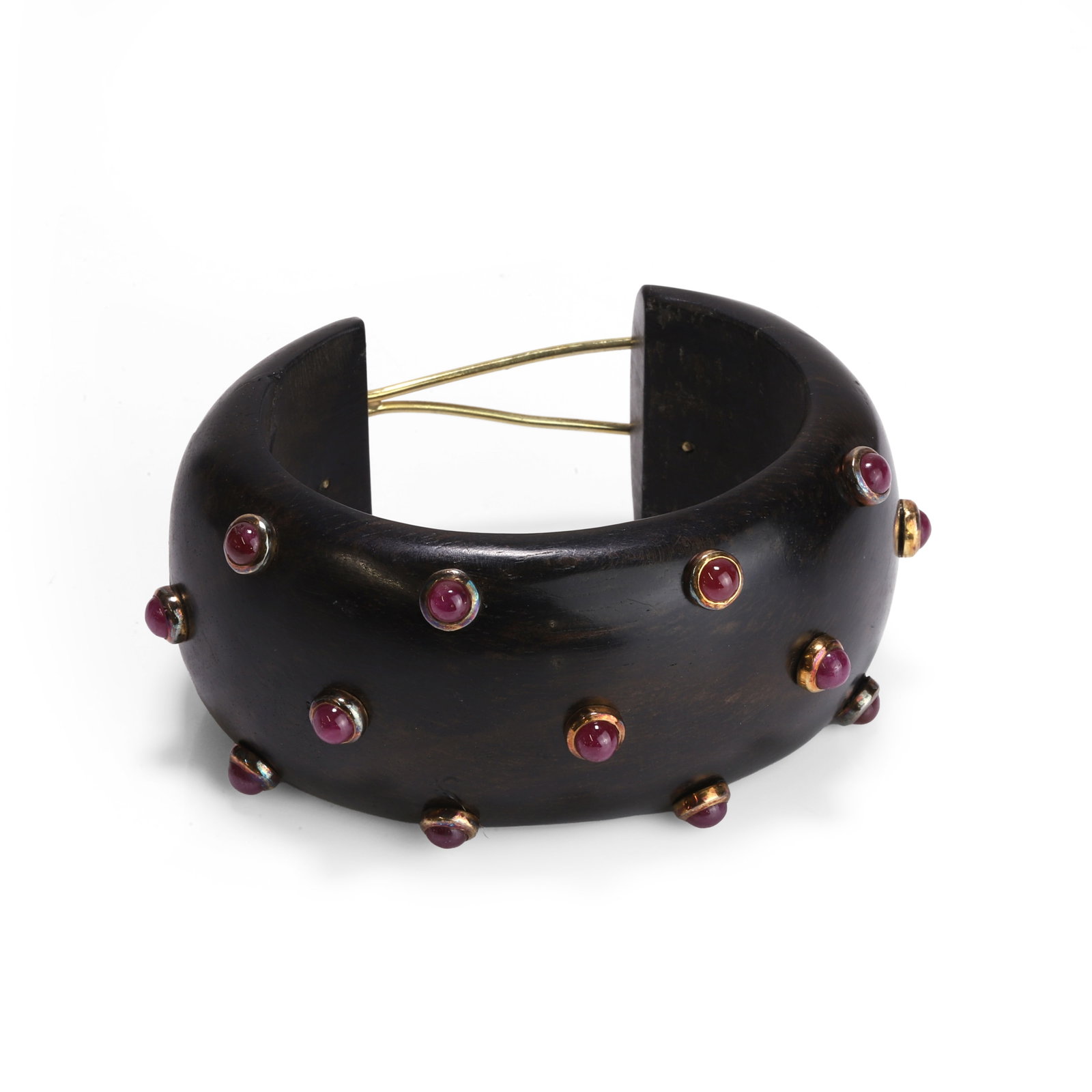 L'Oree du Bois, an ebony and ruby open bangle,: L'Oree du Bois, an ebony and ruby open bangle, the 'D' profile cuff studded with thirteen round cabochon rubies, 'doughnut' set in gold with hinged 'figure of 8' clasp and branded stamped disc to unde