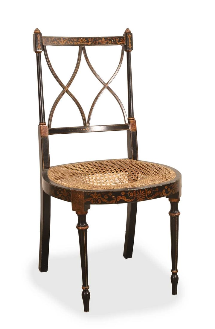 A late Regency style ebonised and parcel gilt cane chair, 19th century,: A late Regency style ebonised and parcel gilt cane chair, 19th century, the top rail with painted foliate ornament above a lattice back, with a caned seat and bowed front rail, raised on ring tapered 