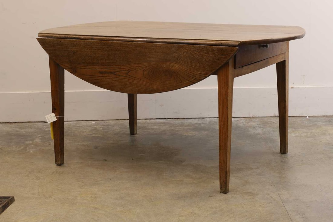 An elm farmhouse drop leaf table, 19th century, French,: An elm farmhouse drop leaf table, 19th century, French, with two end drawers, raised on tapering supports 143cm wide, 83cm deep, extended 133cm deep 73cm high Condition Report: with pot marks to
