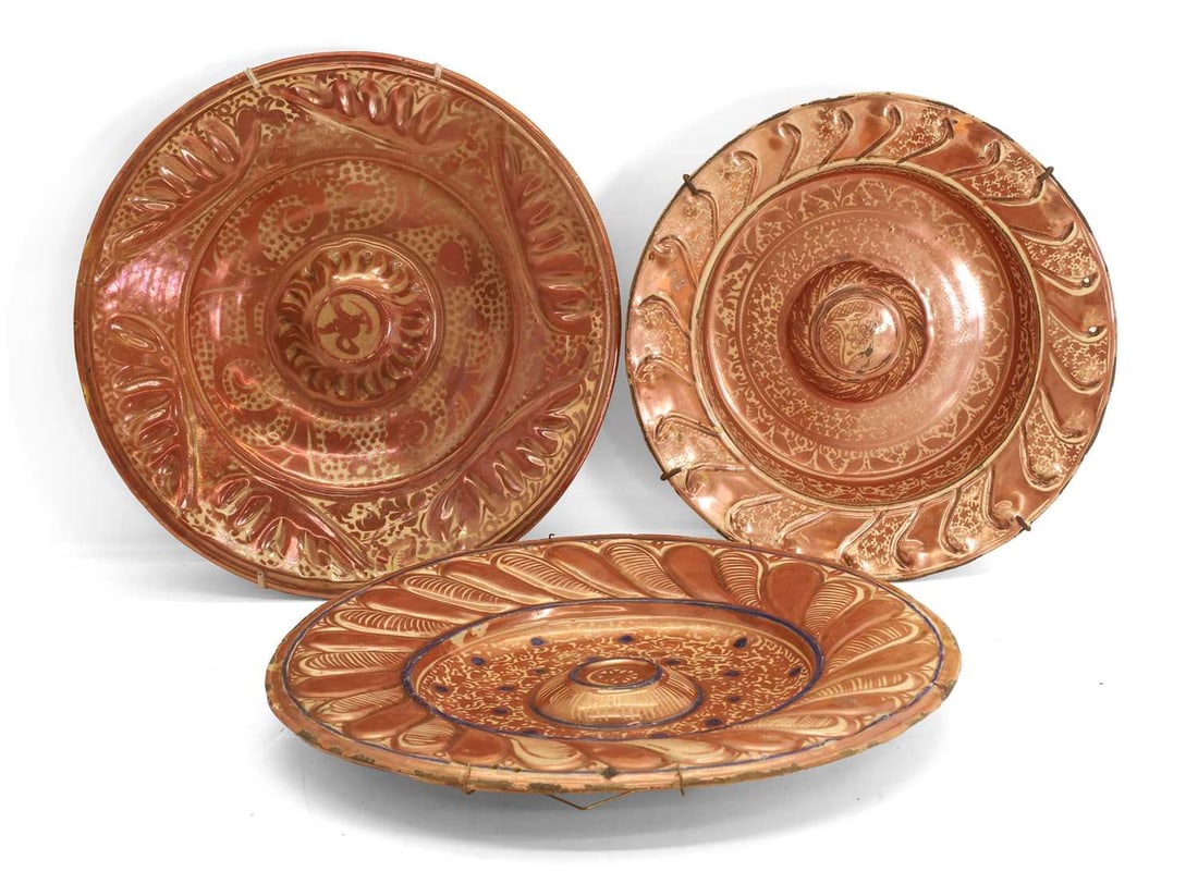 Two Hispano-Moresque copper lustre chargers, 19th century,: Two Hispano-Moresque copper lustre chargers, 19th century, each central convex boss surrounded by scrolling stylised foliage, the wide borders with gadrooned decoration, one example with cobalt,