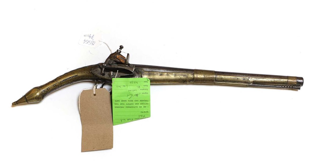 An Ottoman Miquelet pistol, circa 1820,: An Ottoman Miquelet pistol, circa 1820, teak framed with brass inlay Shipping Disclaimer: Shipping Disclaimer Buyers must be aware of their country’s shipping and import policies regarding