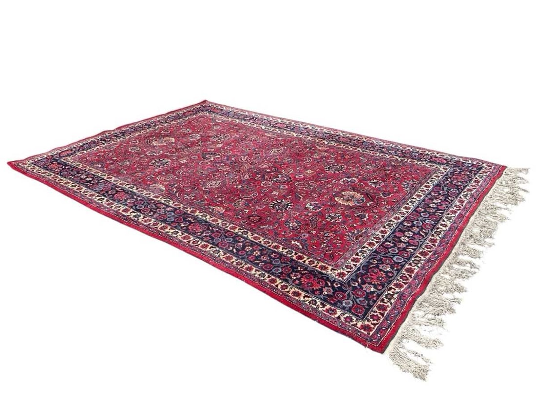 A Khorassan carpet, North West of Iran,: A Khorassan carpet, North West of Iran, the red field densely decorated with stylised palmettes, flowering vines, and scrolling foliage in a dark indigo floral borders 247cm wide, 361cm long,