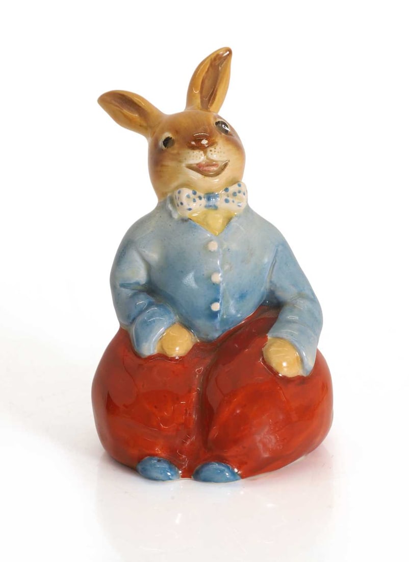 A Royal Doulton Billy Bunnykin, circa 1960s,: A Royal Doulton Billy Bunnykin, circa 1960s, modelled in red trousers and a blue jacket, with an impressed mark to the base '8302', and stamped Royal Doulton Bunnykins mark 7cm wide,10.6cm high