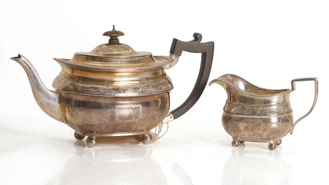 A silver teapot,: A silver teapot, by Reid & Sons (Thomas Arthur Reid, Francis James Langford & Christian Leopold Reid), London, 1905 with ebonised handle, together with cream jug, by William Hutton & Sons 