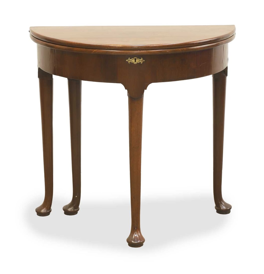 A George II walnut demi-lune card table,: A George II walnut demi-lune card table, with green baise surface, and brass-shaped escutcheon, terminating on pad feet Condition Report: Stable on a flat surface. Green baise surface has been
