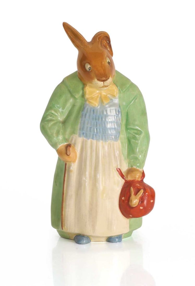 A Royal Doulton 'Farmer' Bunnykin, circa 1960s,: A Royal Doulton 'Farmer' Bunnykin, circa 1960s, modelled in a green jacket and holding a red bag, with an impressed mark to the base, and stamped Royal Doulton Bunnykins mark 10cm wide, 19cm high