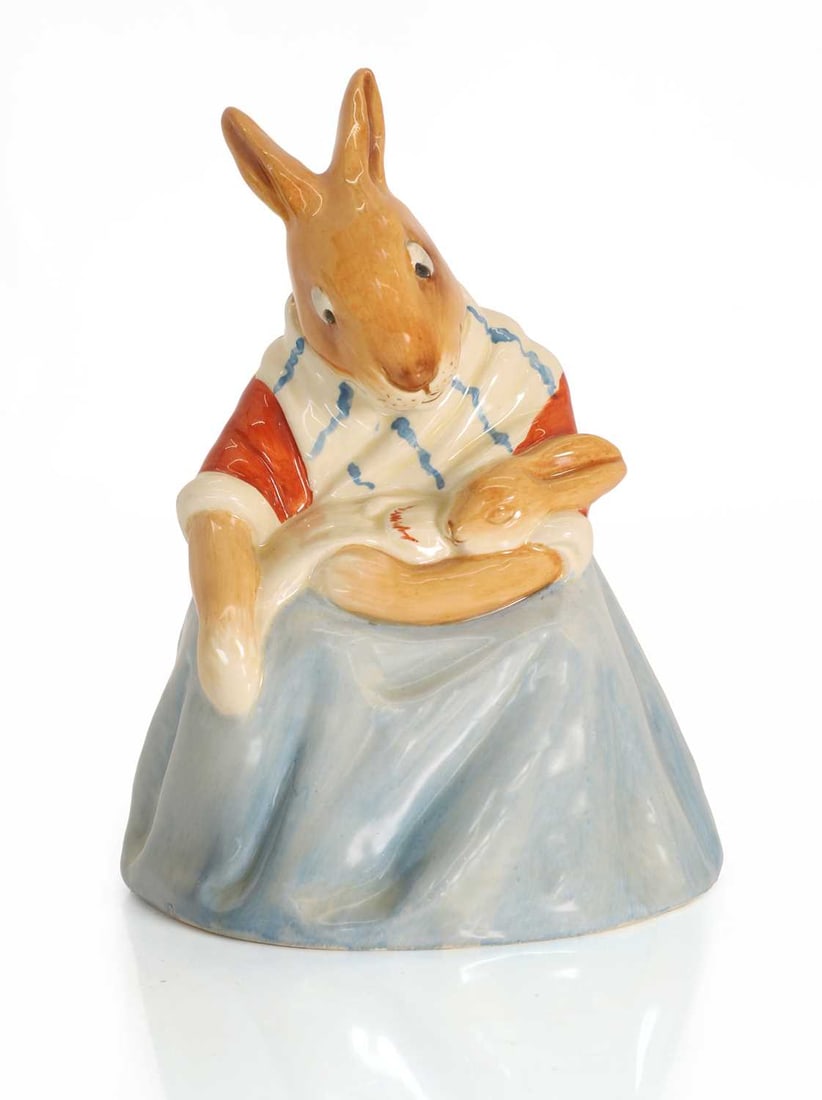 A Royal Doulton mother bunnykin,: A Royal Doulton mother bunnykin, modelled holding a baby bunny in a blue dress, with an impressed mark to the base '8305', and stamped Royal Doulton Bunnykins mark 13.2cm wide, 18.2cm high Condition