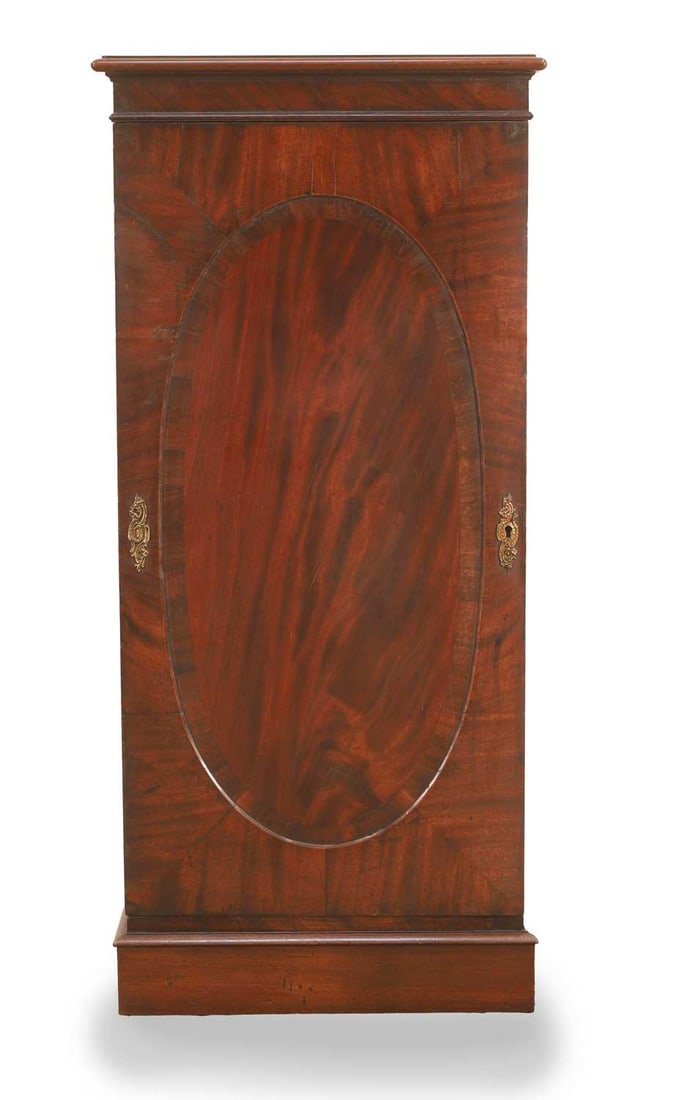 A George III mahogany pedestal cabinet, early 19th century,: A George III mahogany pedestal cabinet, early 19th century, with a moulded top, over an oval oblong crossbanded panel, enclosing three shelves 56cm wide, 33cm deep, 122cm high