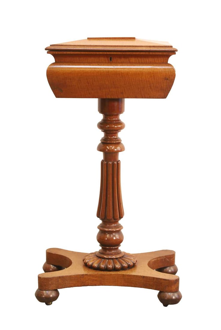 A William IV fiddle back mahogany teapoy, circa early 19th century,: A William IV fiddle back mahogany teapoy, circa early 19th century, the sarcophagus-shaped casket, opening to reveal a well and two lidded compartments, on a turned and reeded column, shaped platform,