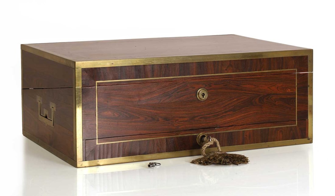 A rosewood writing slope, late 19th century / early 20th century,: A rosewood writing slope, late 19th century / early 20th century, with brass mounts and locks, the interior with dark blue leather writing surface and inkwells 4cm wide, 26cm deep, 16cm high