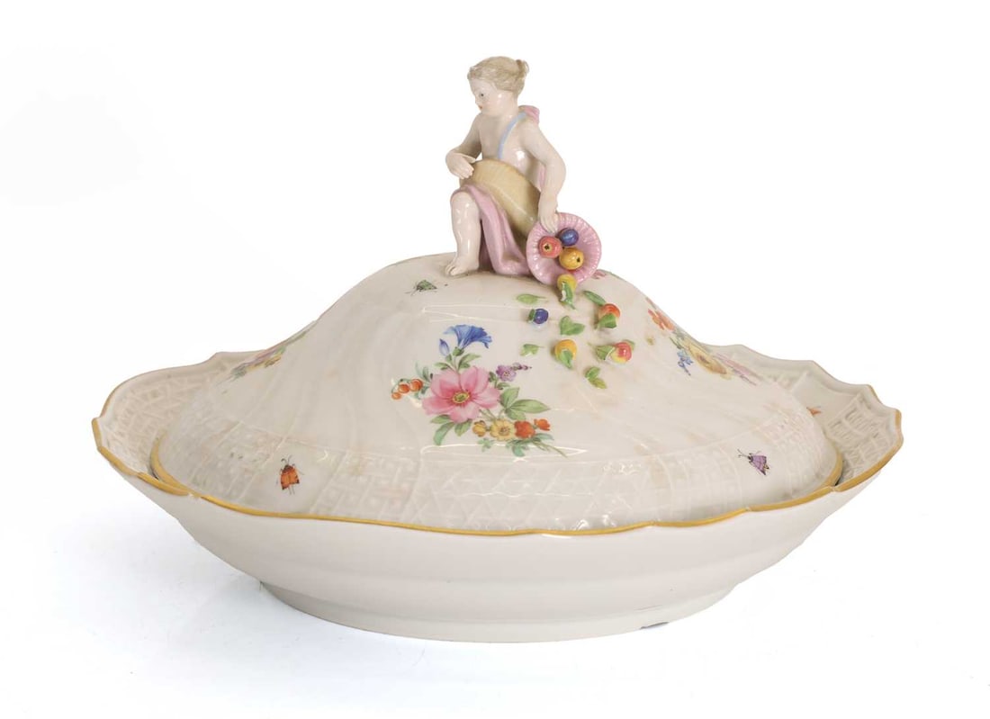 A Meissen tureen and cover, 19th century,: A Meissen tureen and cover, 19th century, the moulded top and base are decorated with bugs and flowers, the lid is surmounted with a cherub with a fruitful cornucopia over its knee, blue painted